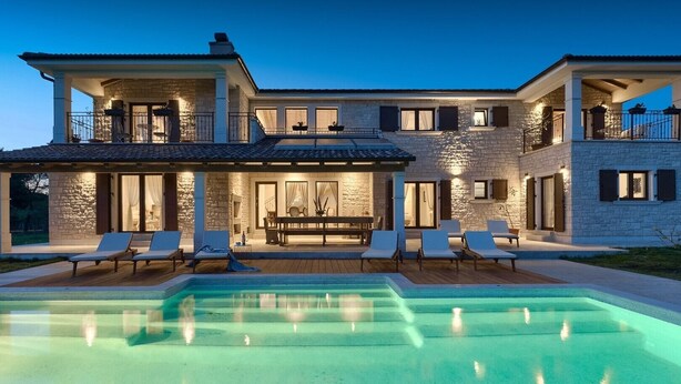 A two-story house with a swimming pool, outdoor seating, and stone walls. - Luxury and Stylish Villa Campagna with sauna, private pool and beautiful garden (Pula)