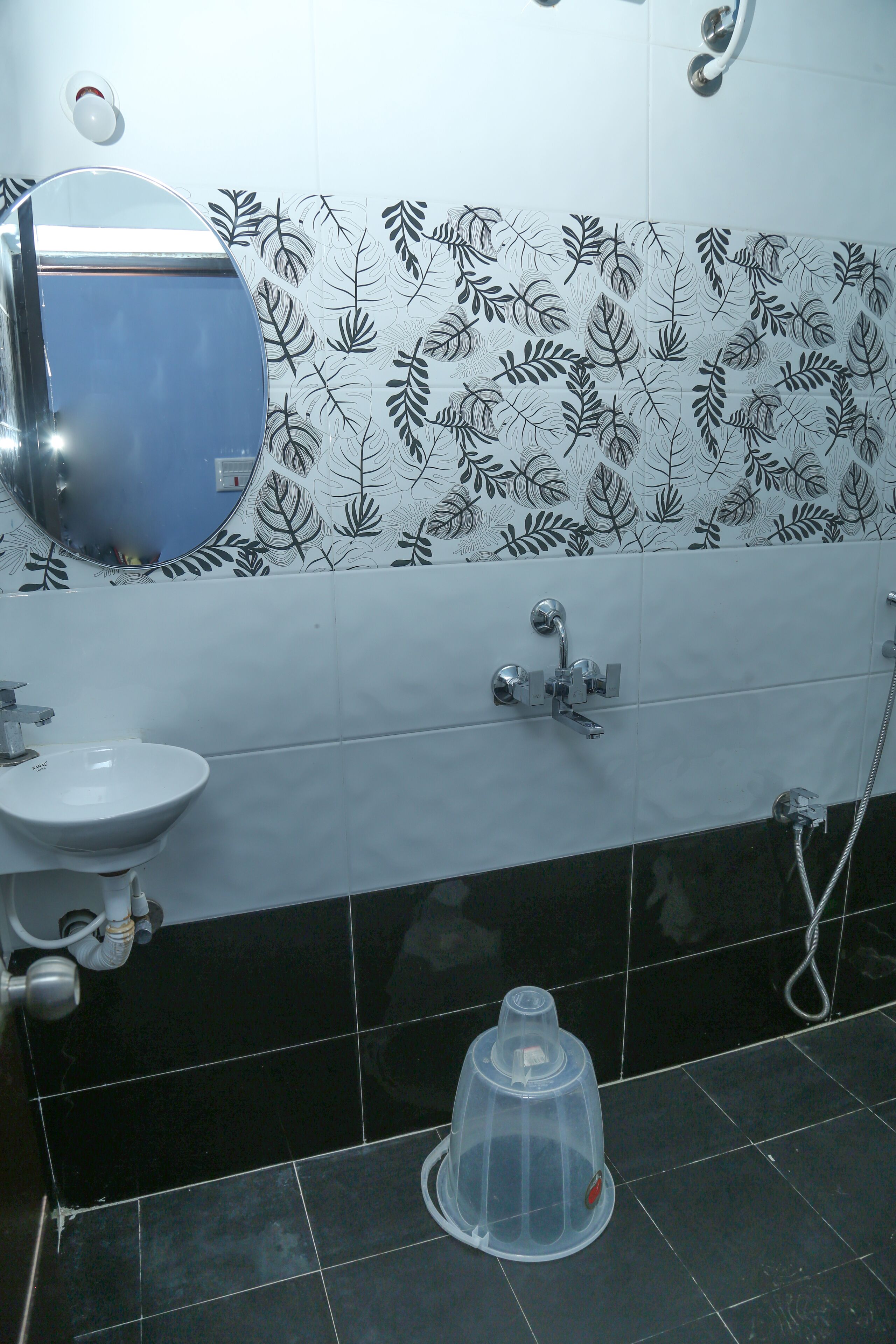 A bathroom with a white sink, a mirror, a shower, and a toilet.