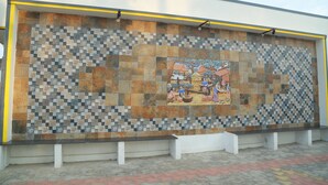 A tiled wall with a mosaic pattern and a bench in front. - Royal Galaxy Inn By Elgozo (Yercaud)
