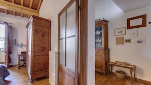 A room with wooden furniture, a cabinet, and a wall with framed pictures. - Central Panoramic Terrace (Florence)