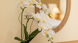 A white orchid in a white pot on a wooden dresser with a mirror above it. - The HUB Hotel (Ho Chi Minh City)