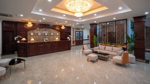 A spacious lobby with a reception desk, seating area, and decorative lighting. - The HUB Hotel (Ho Chi Minh City)