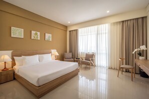 A hotel room with a large bed, two chairs, a desk, and a window with curtains. - The HUB Hotel (Ho Chi Minh City)