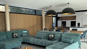A modern living room with a sectional sofa, a wooden coffee table, and pendant lighting. - Luxury villa heated pool jacuzzi sauna (Pérols)