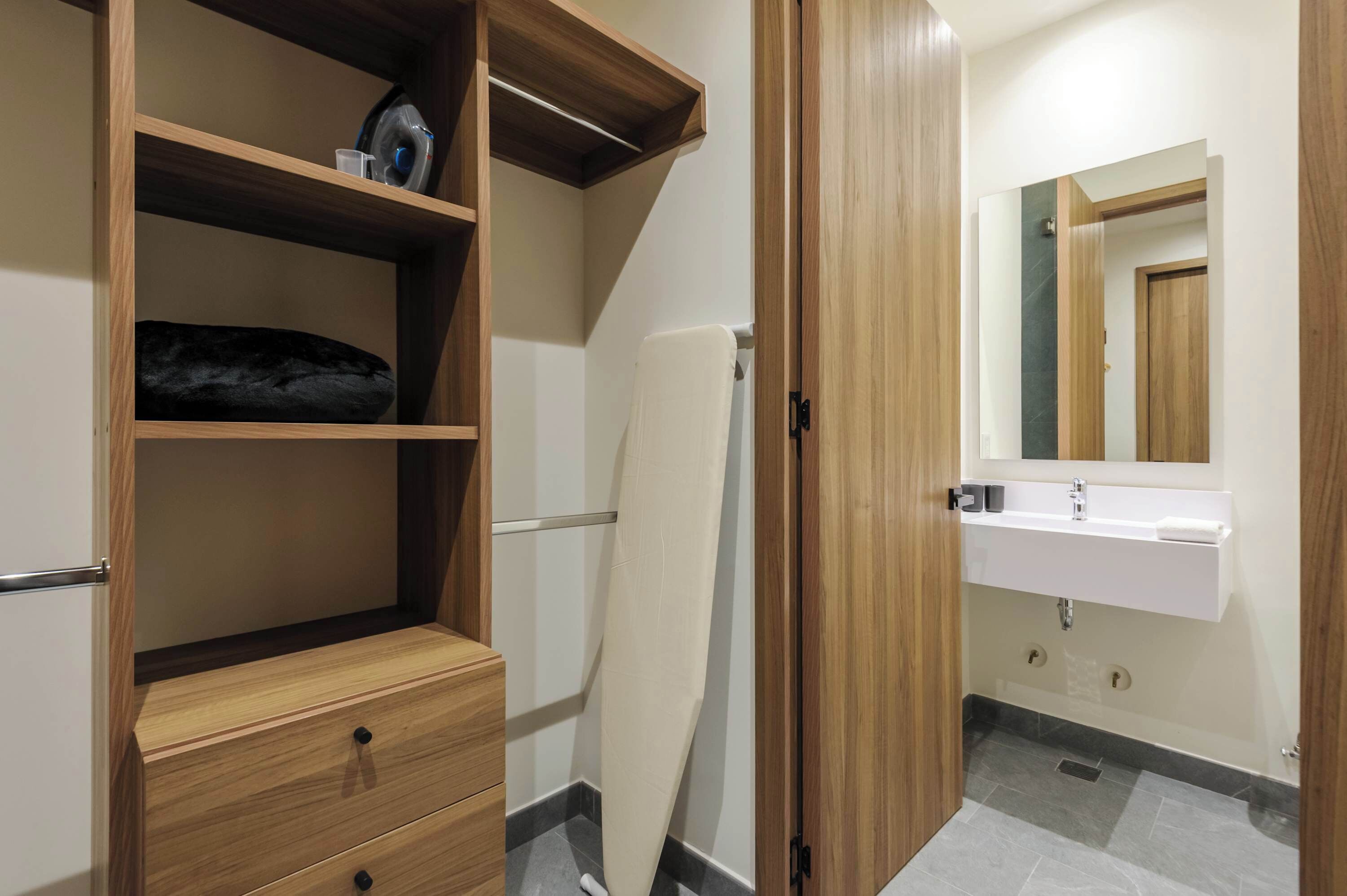 Une salle de bain avec un meuble-lavabo en bois, un évier et un miroir.