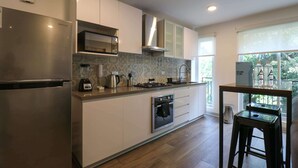 Una cocina moderna con electrodomésticos de acero inoxidable, horno empotrado y cocina a gas.