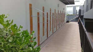 Un pasillo con panel de madera en la pared, barandales de metal y piso estampado.