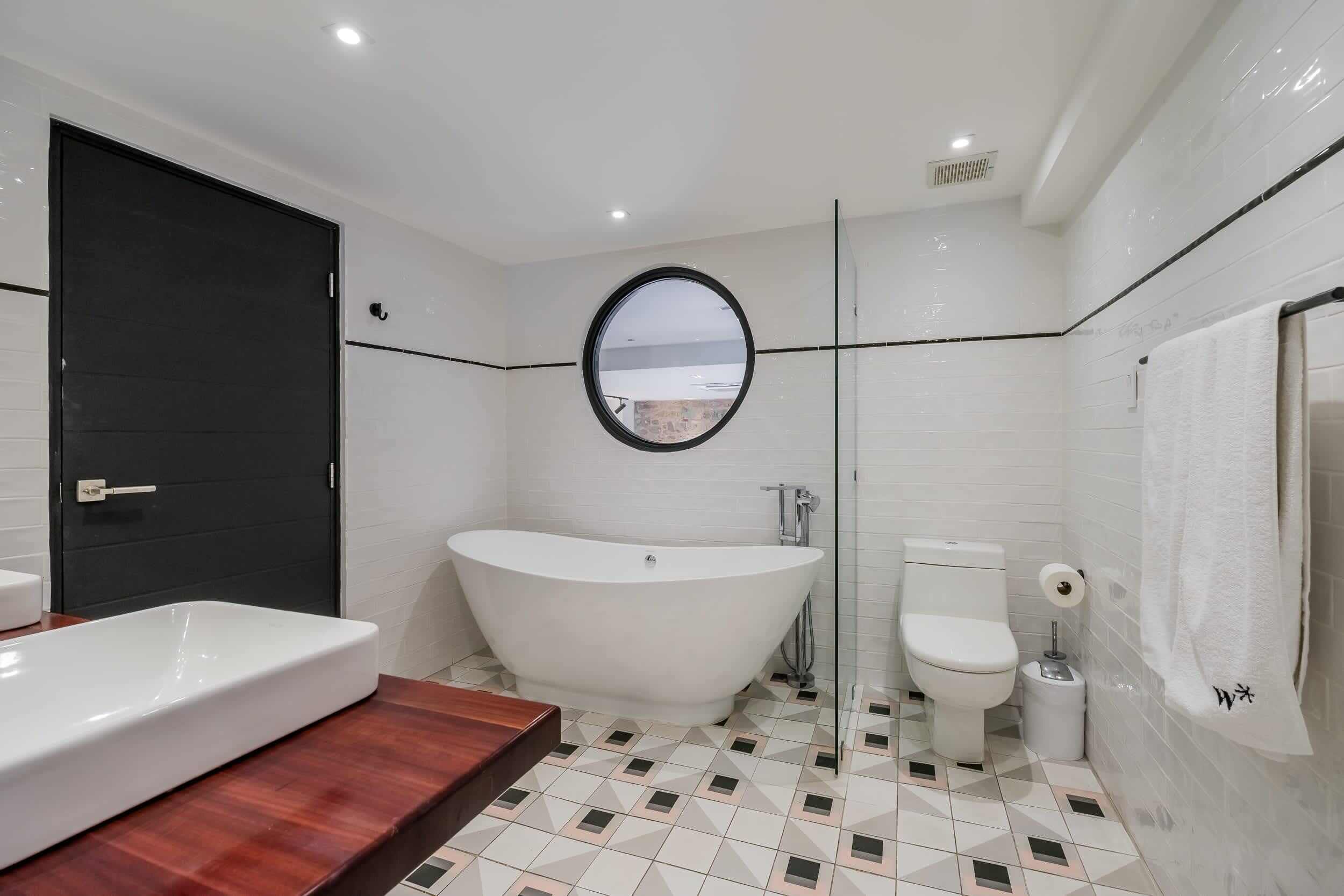 A modern bathroom with a freestanding bathtub, a toilet, and a sink.