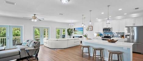 A modern kitchen with white cabinets, stainless steel appliances, and a large island with stools.