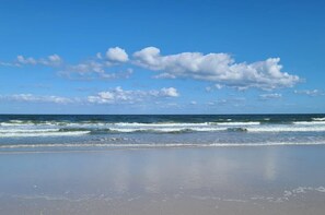 Ein Strand mit Wellen und blauem Himmel.