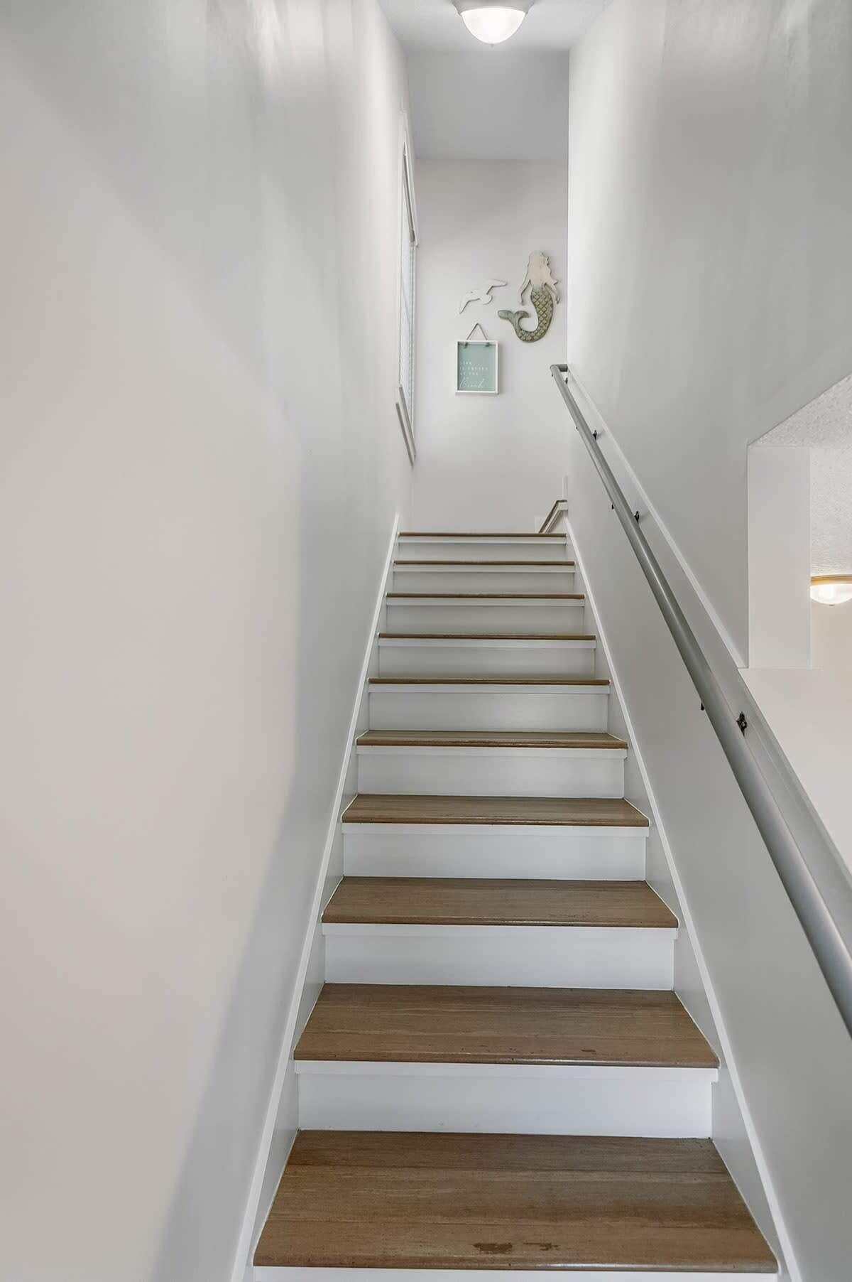 A staircase with white walls and wooden steps.