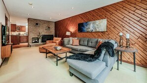 Una sala de estar moderna con chimenea, un sofá, una mesa de centro y un televisor.