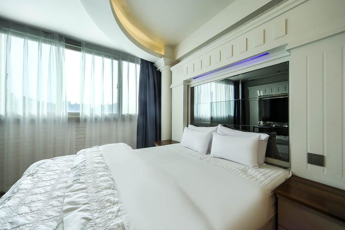 Una camera d'albergo con un letto grande, un armadio a muro e vista sulla città.