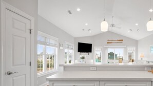 A spacious kitchen with white cabinetry, a large island, and a view of the backyard. - Ocean Views. Clean! Pup Friendly. 2 Min Walk to the Beach. Beach Gear Included (Surf City)