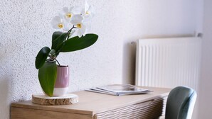 A wooden desk with a vase of white orchids, a pink vase, and a notebook. - La Bastide de Montferrat (Montferrat)