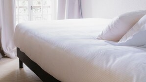 A bedroom with a bed, white curtains, and a window with a view of greenery. - La Bastide de Montferrat (Montferrat)