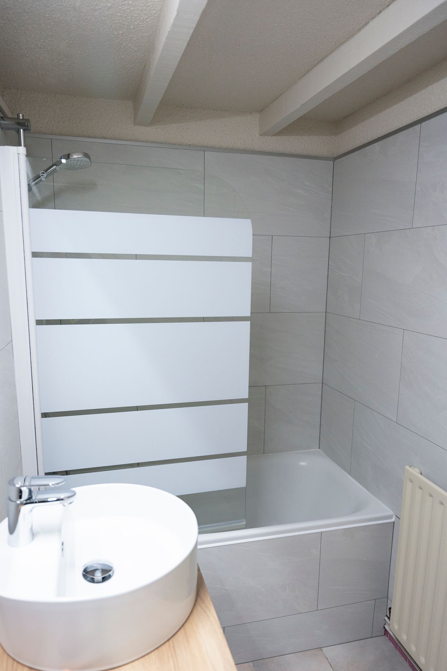 A bathroom with a white sink, a shower, and a bathtub.