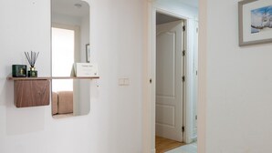 Ein Flur mit einem Spiegel, einer Dankeskarte und einem gerahmten Bild an der Wand.