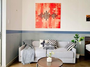 Relax in this stylish living room with a sofa, coffee table, and vibrant artwork.