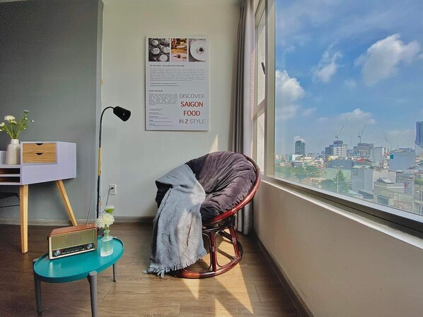 Enjoy a city view from the large window, relax in the comfortable seating area with a cushioned chair and side table.