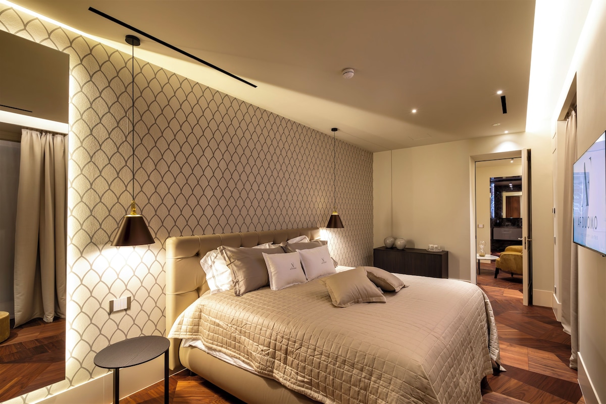 A modern bedroom with a large bed, a bedside table, and a nightstand.