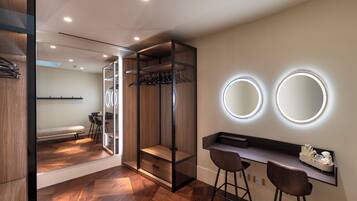 A modern bathroom with a vanity, two mirrors, and a bench.