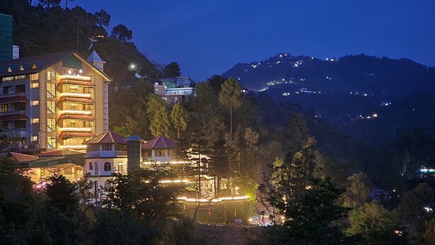 Un hotel de varios pisos con balcones y una fachada bien iluminada.