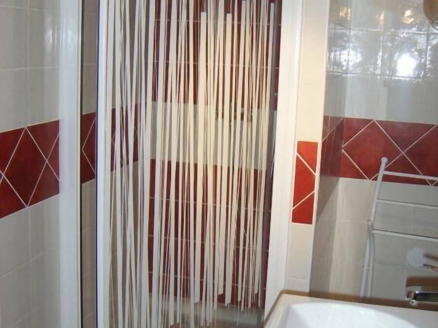 Un baño con cabina de ducha, lavamanos y paredes de azulejos.
