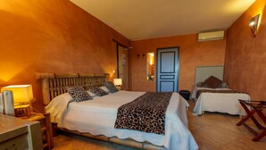 Una habitación con una cama grande, dos camas más pequeñas, un escritorio y una silla.