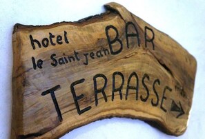 A wooden sign with the text "hotel le Saint Jean BAR TERRASSE" and an arrow pointing to the right. - Hôtel Le Saint Jean  (Ersa)