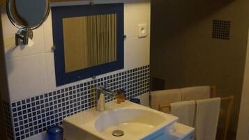 A bathroom with a sink, mirror, and towel rack.