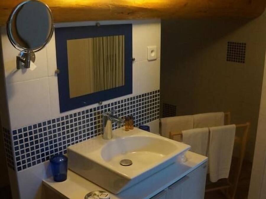 A bathroom with a sink, mirror, and towel rack.