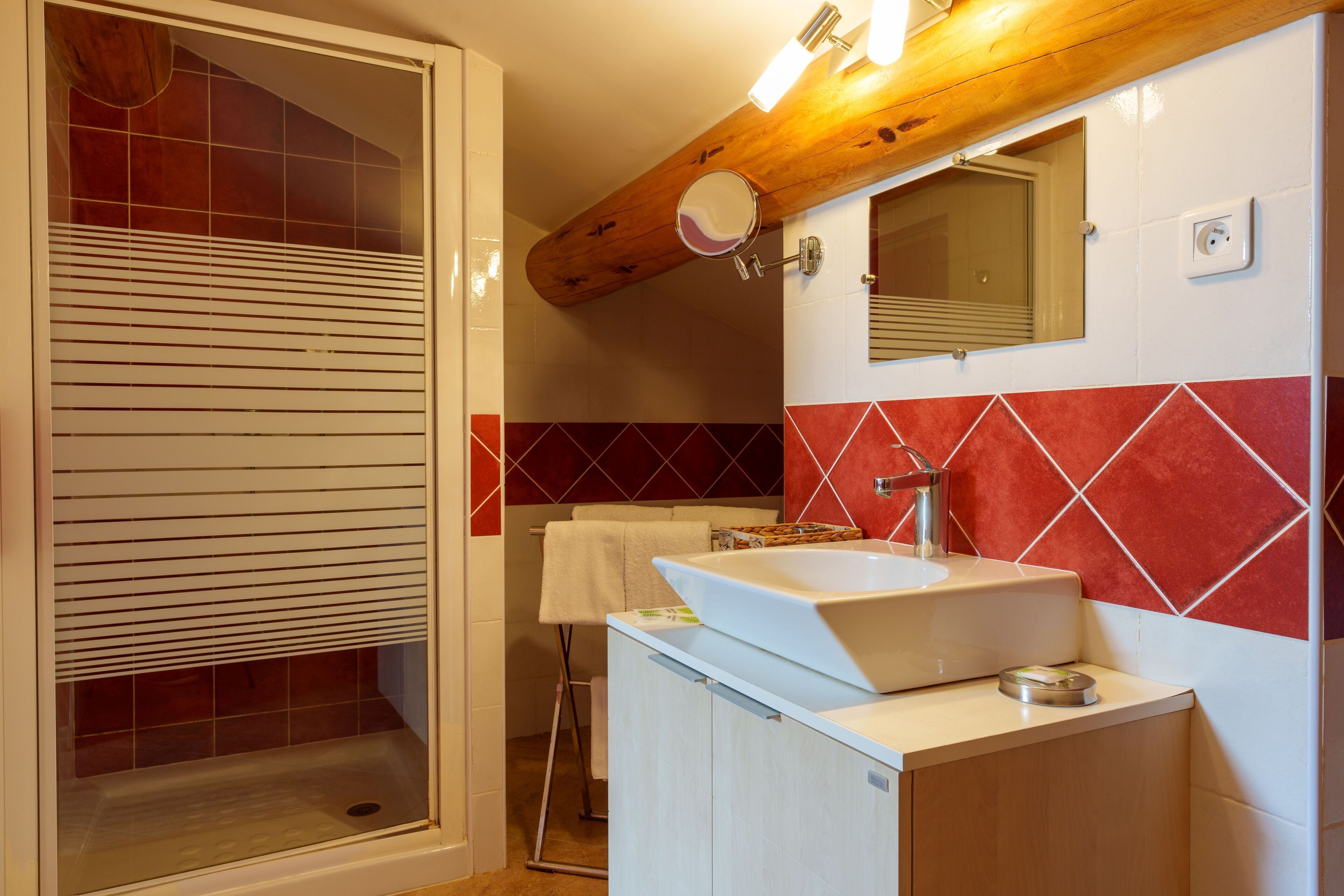 Un baño con ducha, lavamanos y espejo.