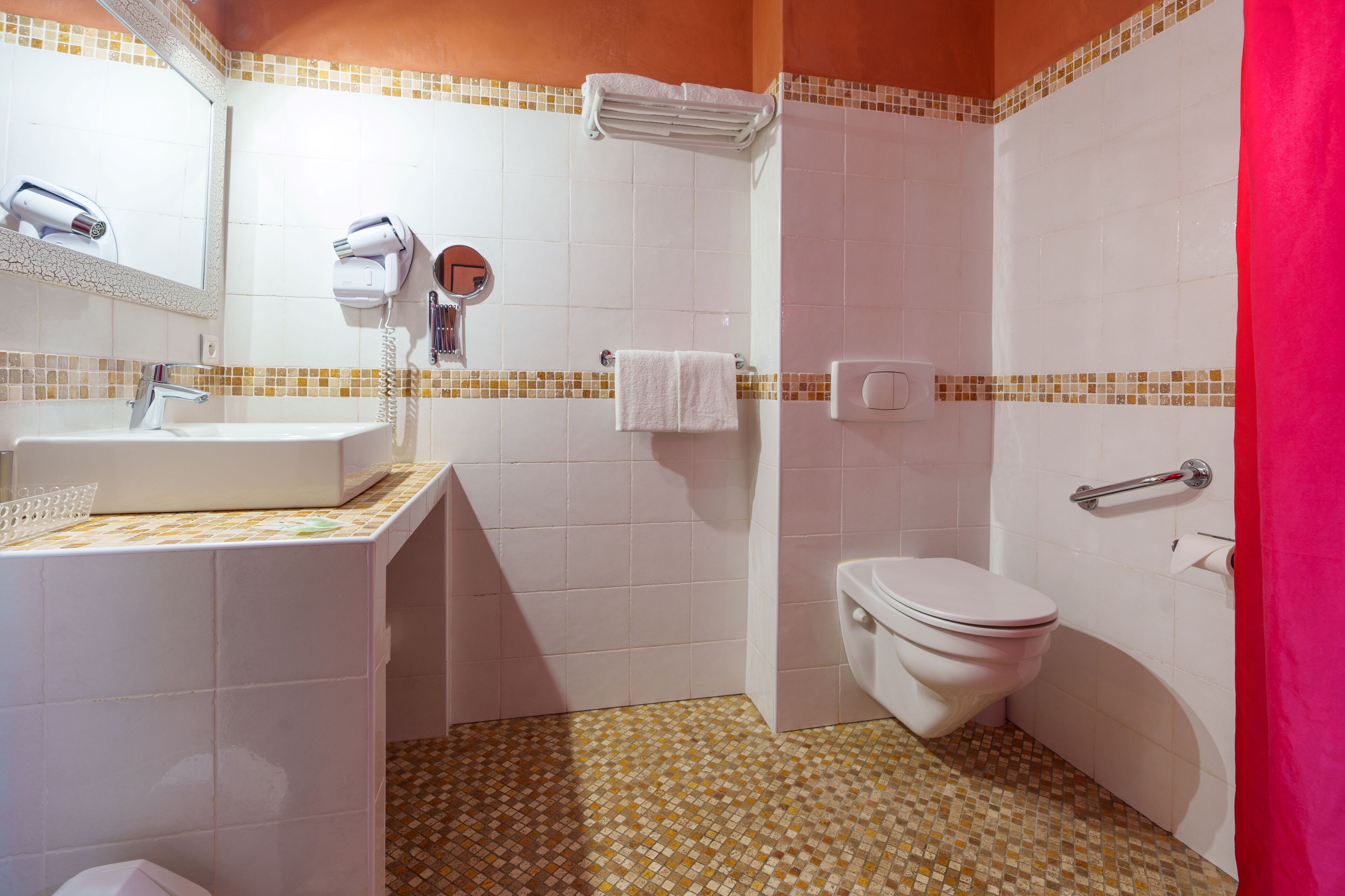 A bathroom with a sink, mirror, towel rack, and toilet.