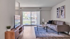 Un salon moderne avec un canapé, une table basse et un meuble pour la télévision.