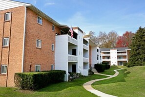 A multi-story building with a brick facade, a white exterior, and a flag on the top.