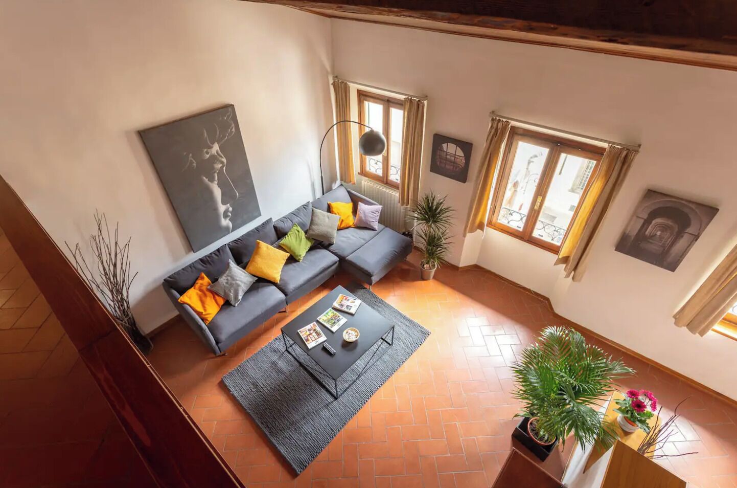 A living room with a sofa, a coffee table, and a potted plant.