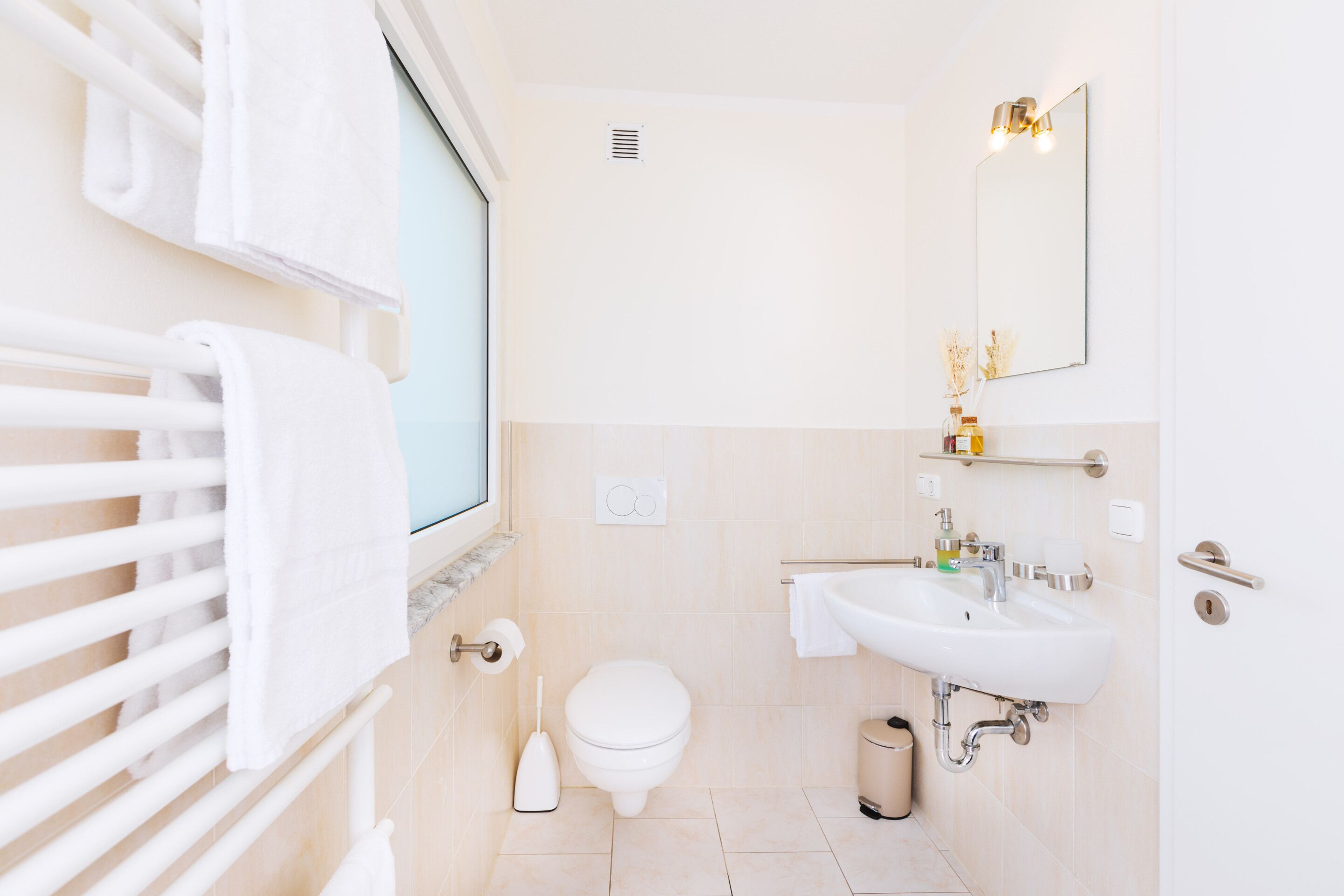 Ein Badezimmer mit Toilette, Waschbecken, Spiegel und Handtuchhalter.