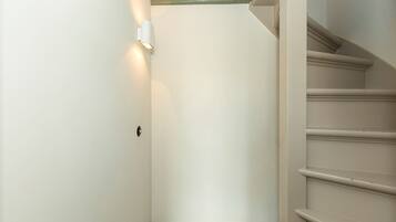 Un escalier avec une rampe et un luminaire fixé au mur.