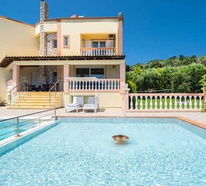 A two-story building with a swimming pool, a balcony, and a stone chimney. - Villa Roula With Private Pool (Chania)