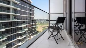 En moderne lejlighed med balkon, store vinduer og udsigt til en golfbane.