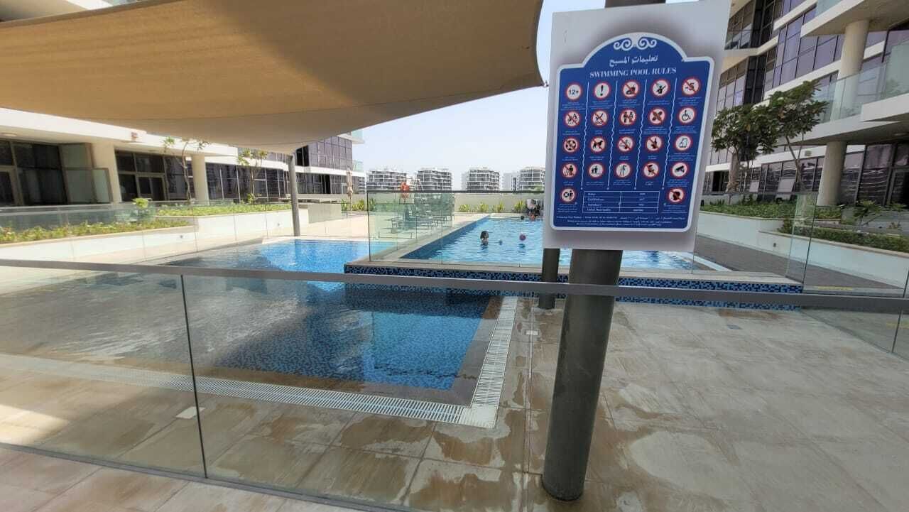 Ein Schwimmbeckenbereich mit einem Schild, das die Schwimmbadregeln auflistet.