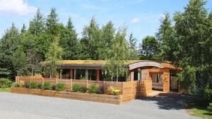 A modern wooden cabin with a green roof, surrounded by dense forest. - Twenty One -  a lodge that sleeps 12 guests  in 6 bedrooms (Richmond)