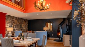 A dining area with a wooden table, wicker chairs, and a chandelier. - Georgia -  a cottage that sleeps 6 guests  in 3 bedrooms (Richmond)