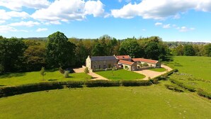 A stone house with a red-tiled roof, surrounded by a well-maintained lawn and a stone wall. - Georgia -  a cottage that sleeps 6 guests  in 3 bedrooms (Richmond)