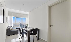 Ein modernes Wohnzimmer mit Essbereich, großen Fenstern und Blick auf die Stadt.