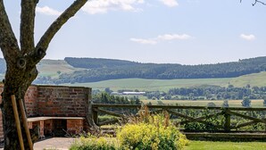 A grassy area with a tree, a brick structure, and a view of distant hills. - Hollins Farmhouse -  a house that sleeps 10 guests  in 5 bedrooms (Leyburn)