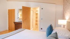 A bedroom with a bed, a dresser, a mirror, and a nightstand with a lamp. - Cara -  a lodge that sleeps 6 guests  in 3 bedrooms (Richmond)