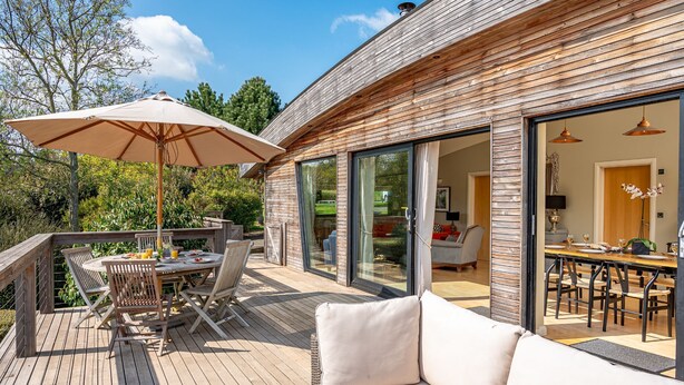 A wooden deck with a dining table, chairs, and a sofa. - Juniper -  a lodge that sleeps 6 guests  in 3 bedrooms (Richmond)
