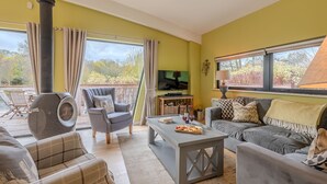 A cozy living room with a fireplace, comfortable seating, a television, and a dining area with a table set for two. - Louis -  a lodge that sleeps 6 guests  in 3 bedrooms (Richmond)